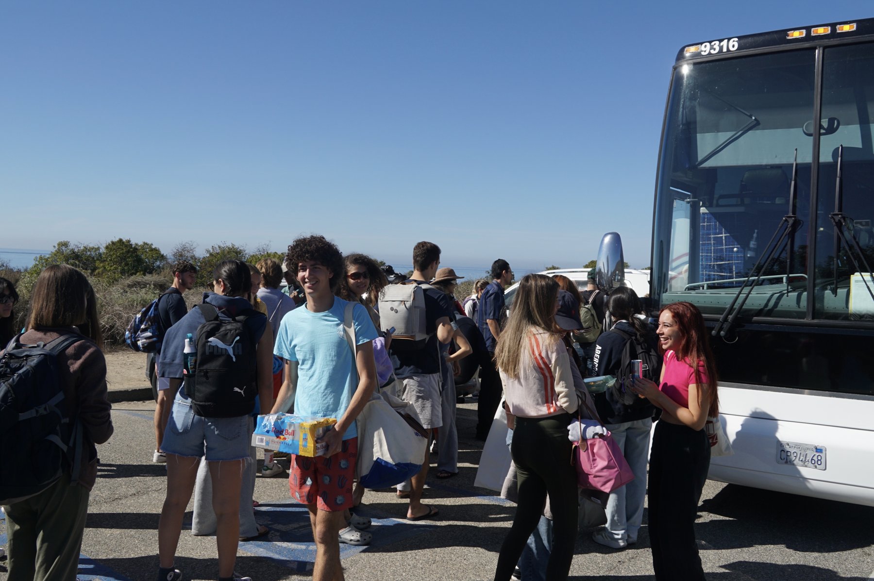 Students unloading from the shuttle bus above the ocean